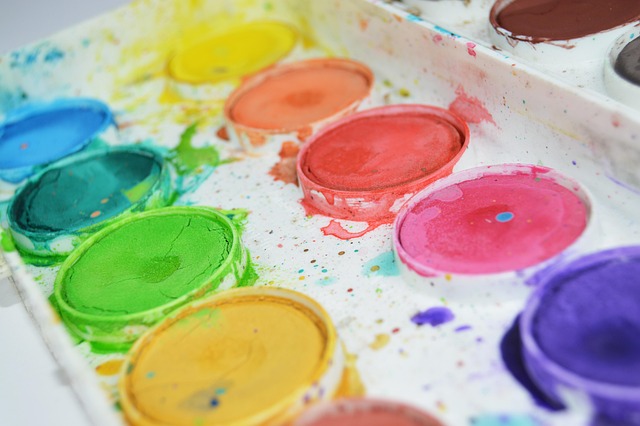 Close-up of a watercolor paint palette with vibrant colors.